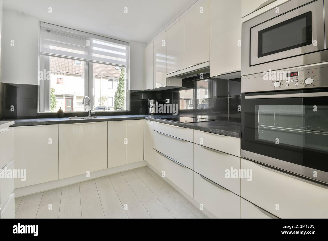 a modern kitchen with white cabinets and black counter tops on the counters in this photo is taken from the inside Stock Photo