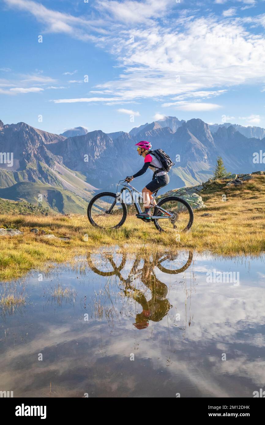 Italy, Veneto, province of Belluno, Falcade. Young girl riding an e-bike / e-mtb, free ride in the Dolomites Stock Photo