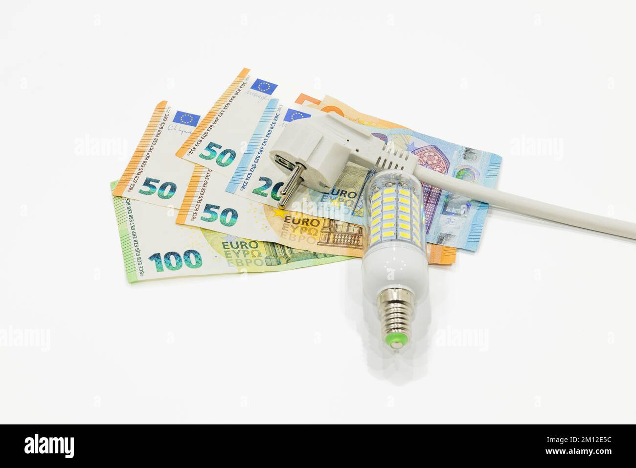 Electric plug, light bulb, and the euro money banknotes. Concept of increasing energy costs Stock Photo