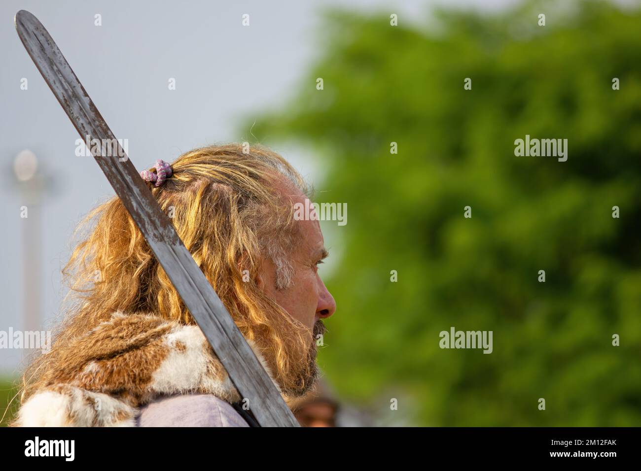 AQUILEIA, Italy - June 22, 2014 - Close-up of a blonde man seen in profile playing the part of an ancient celtic warrior at the historical reenactment Stock Photo