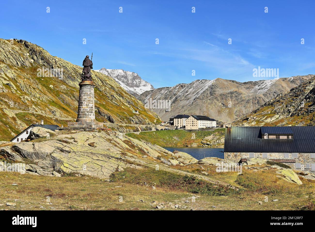 Statue of Saint Bernard behind Hospice and Monastery of the Augustinian Canons, Great Saint Bernard Pass, Colle del Gran San Bernardo, Col du Grand Sa Stock Photo