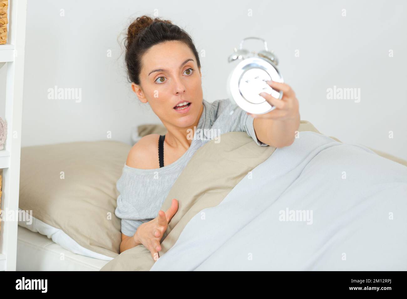 woman waking up late in morning turning off alarm clock Stock Photo Alamy