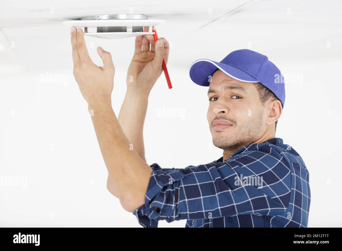 contractor taking ceiling measures with pencil Stock Photo