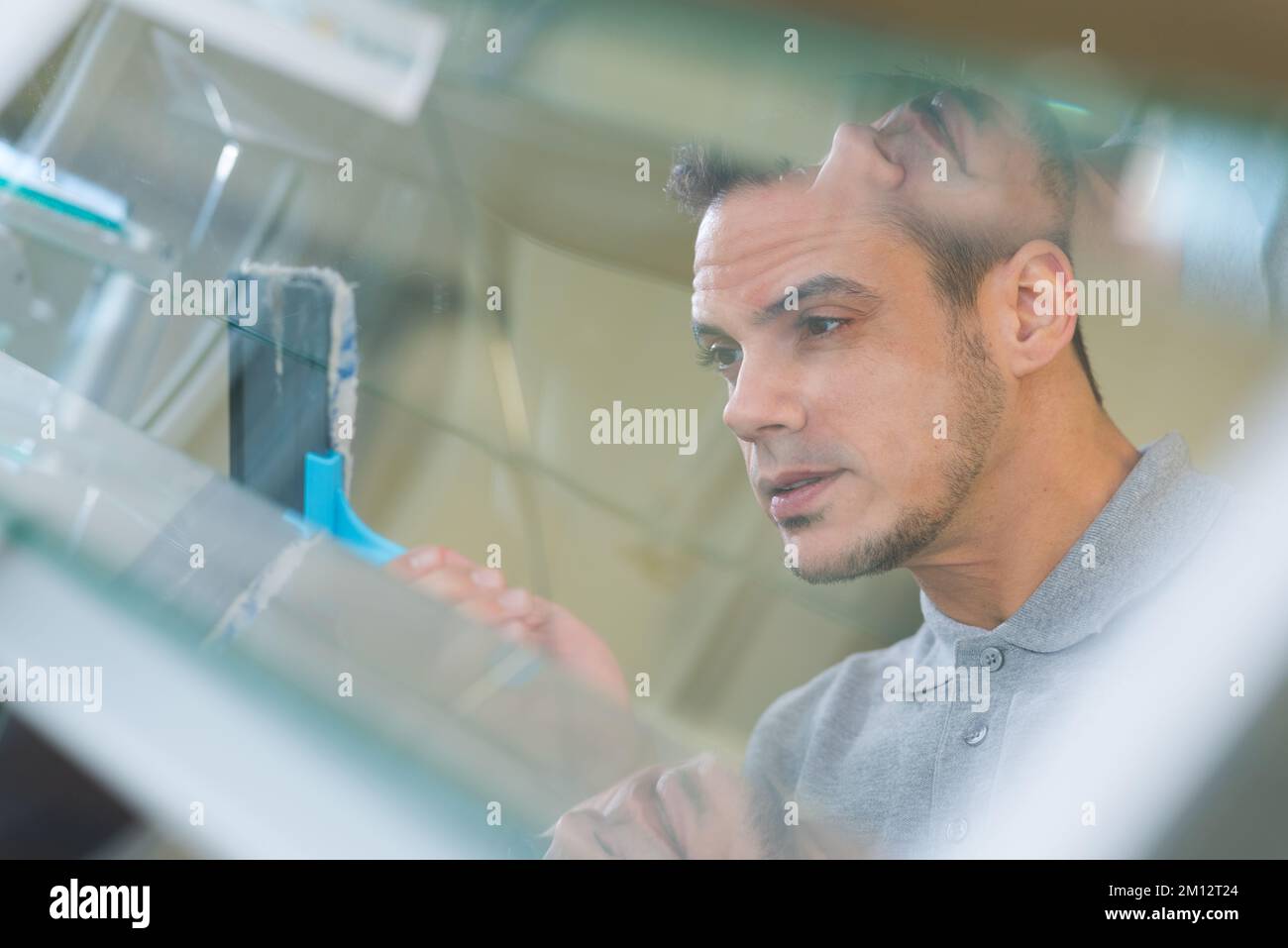 reflected view of man cleaning glass louver window Stock Photo Alamy