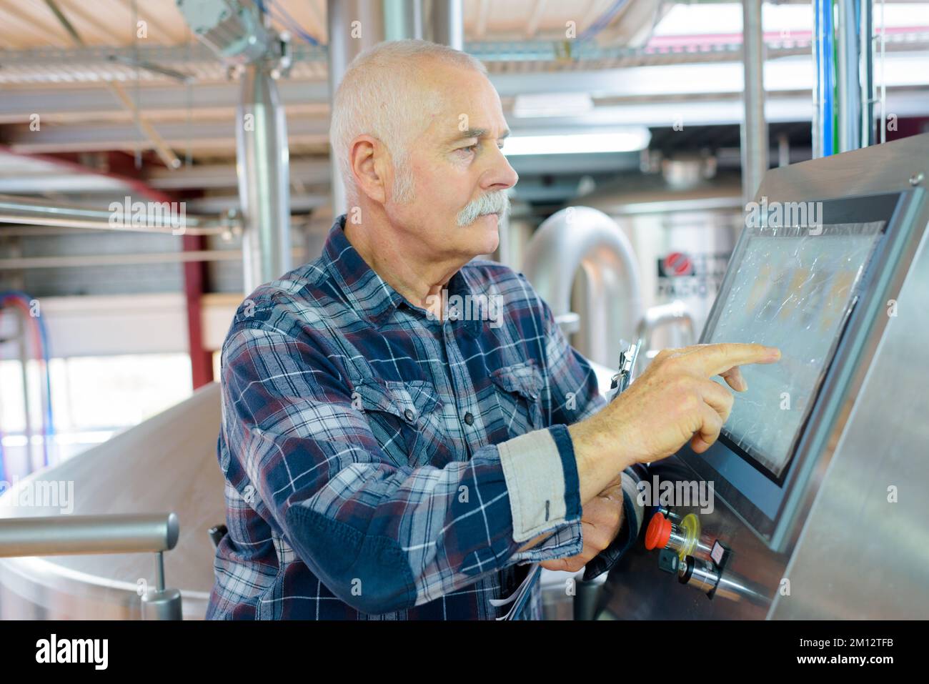 senior operating machine in factory Stock Photo