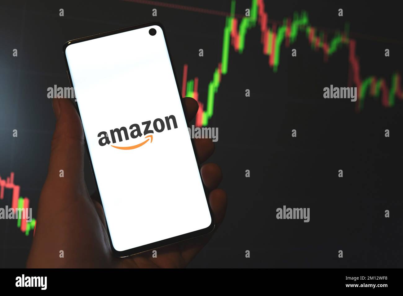 Amazon Inc. logo displayed on phone screen in hand, stock chart, line graph bar dark background. Swansea, UK - August 26, 2021. Stock Photo