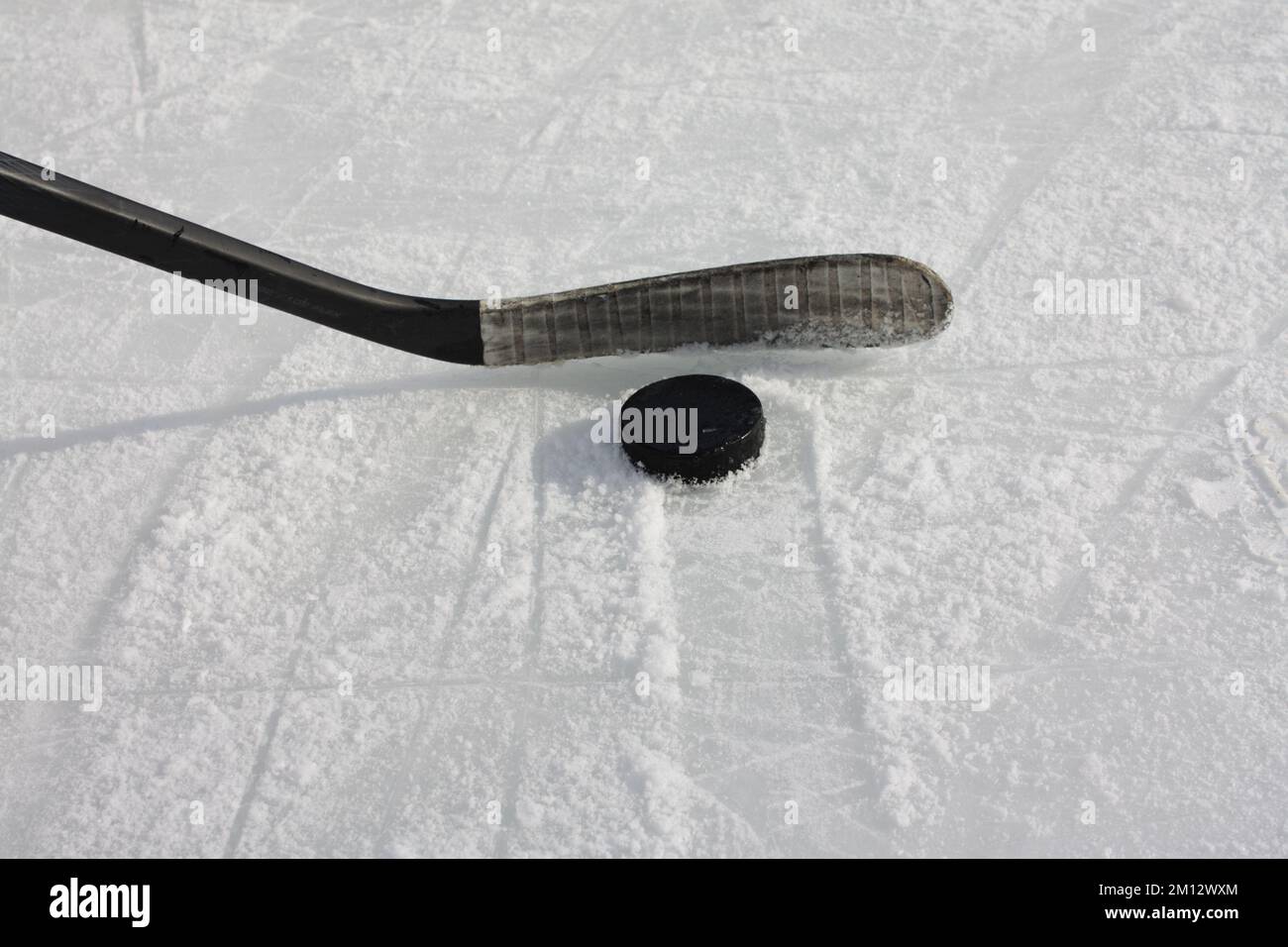 Hockey Stick and Puck on Ice Rink Stock Photo Alamy