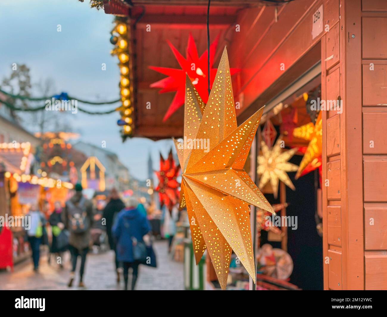 Illuminated poinsettia at a Christmas market at a Christmas hut in the pedestrian zone closeup Stock Photo