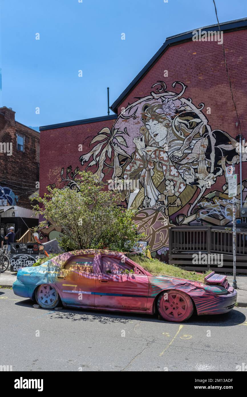 TORONTO,CANADA June 18, 2022: Graffiti Car in Kensington Market.  Kensington Market is a distinctive multicultural neighborhood. Stock Photo