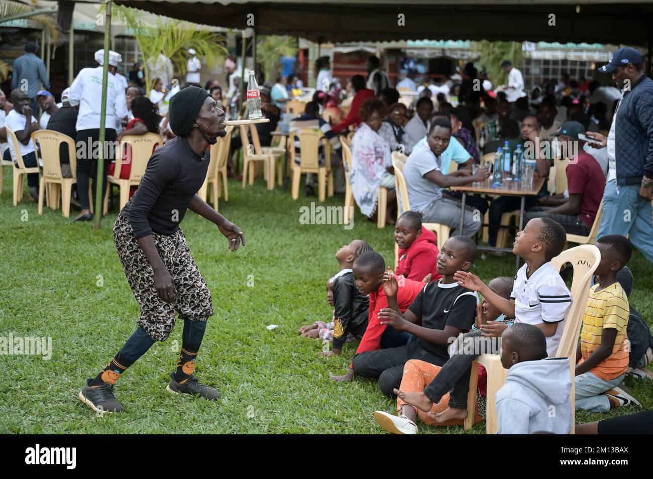 KENYA, Nairobi, middle class in beer garden, acrobatic performance / KENIA, Nairobi, Mittelklasse im Biergarten, akrobatische Vorführung zur Unterhaltung der Gäste Stock Photo
