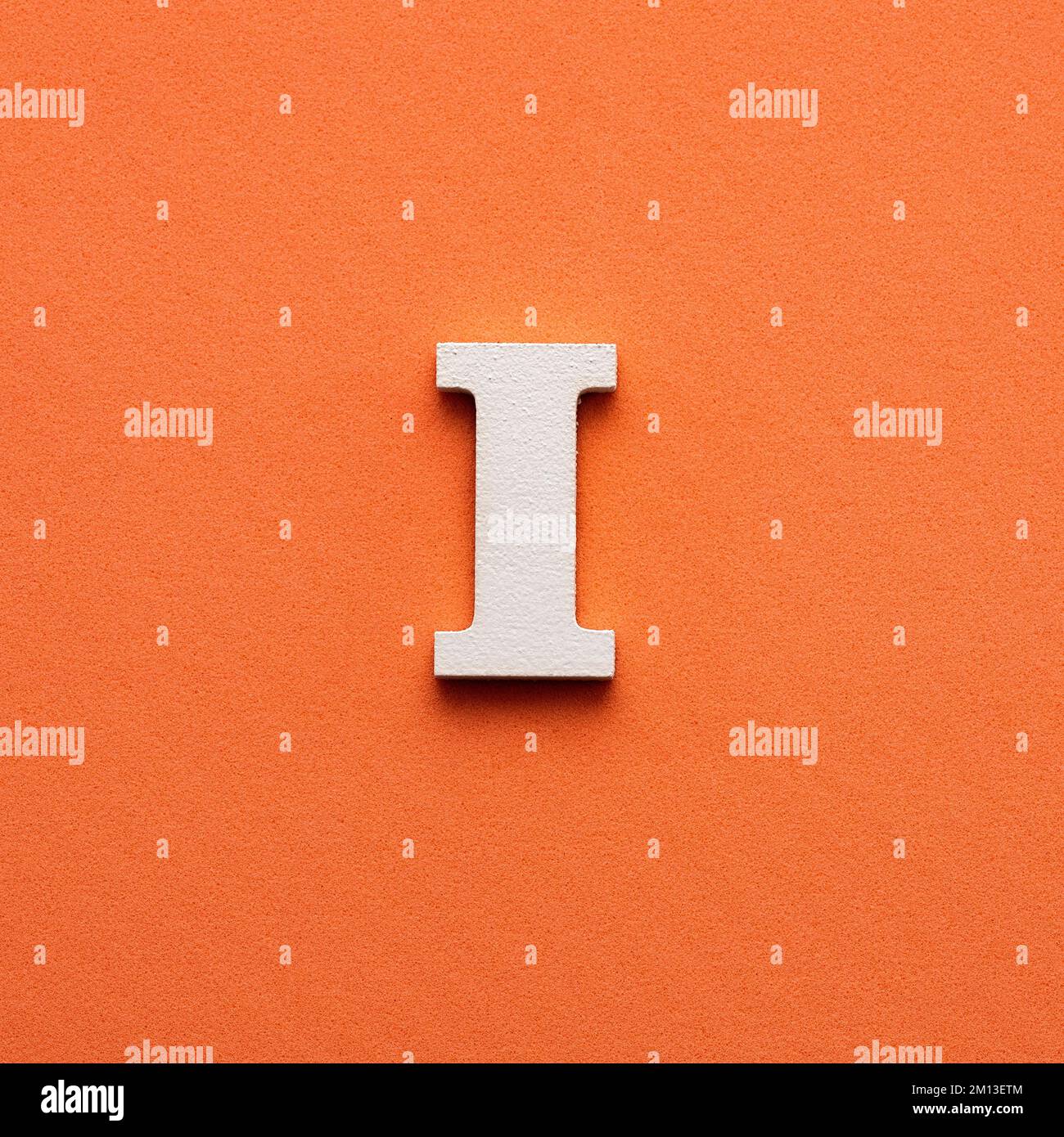 Letter i uppercase white wooden font on pink background stock photo