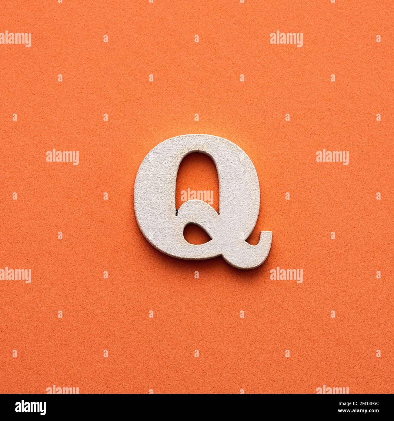 Letter Q uppercase - white wooden font on pink background Stock Photo