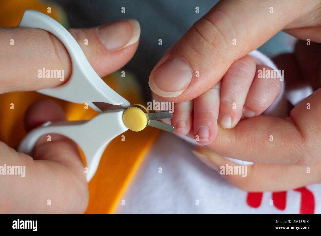 Close up of mom cutting child's nails. Mom cutting new born baby nails