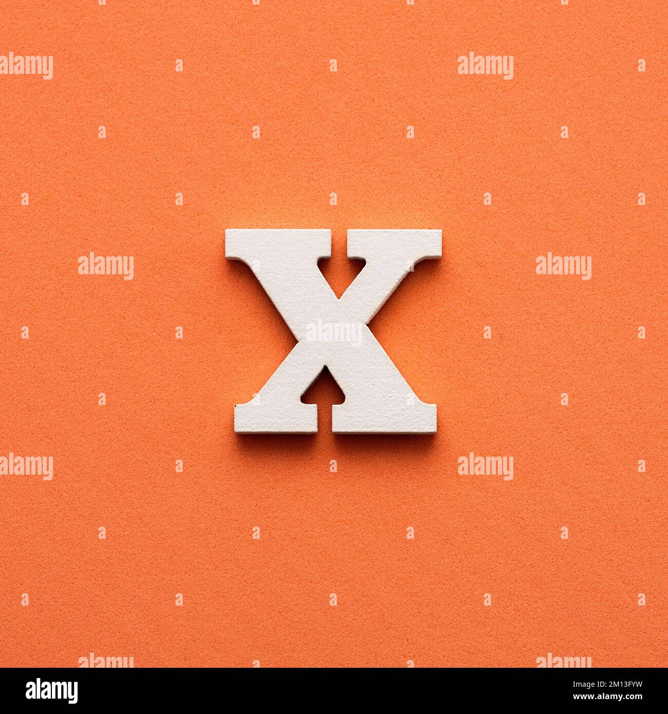 Alphabet letter X White wooden letter on pink background Stock Photo