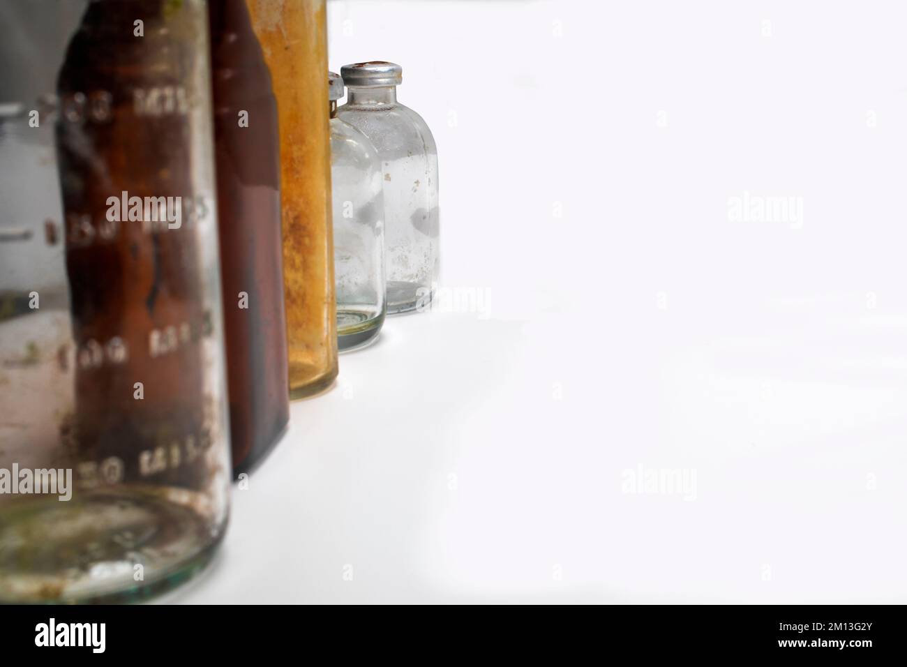 One medical beaker, one amber glass medical pill bottle, One glass test