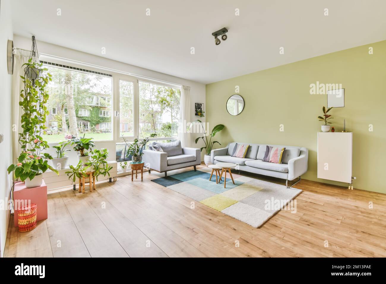 a living room with green walls and wood flooring in the middle of the ...