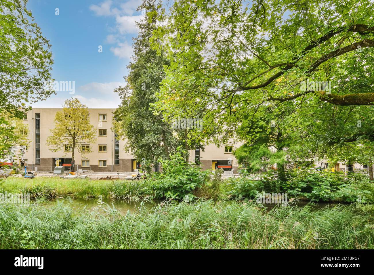 an apartment complex in the netherlands with trees and plants on either