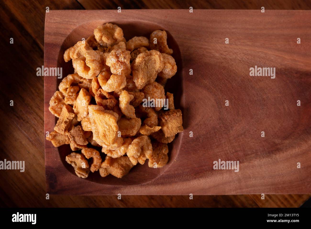 Chicharrones. Deep fried pork rinds, crispy pork skin pieces, traditional mexican ingredient or snack served with lemon juice and red hot chili sauce. Stock Photo