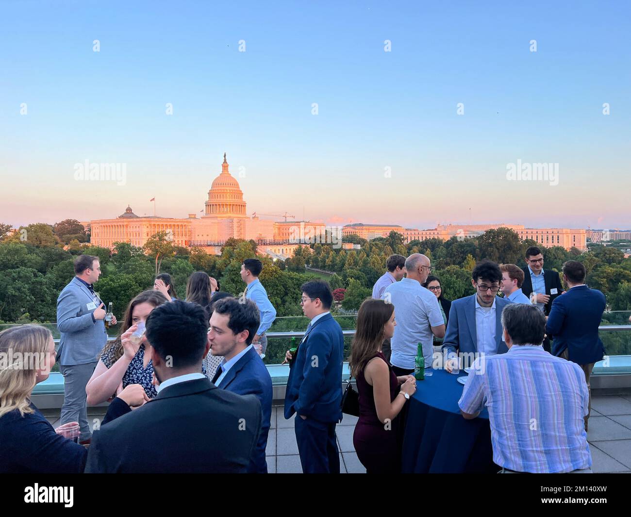 A groups of people networking on a rooftop patio in Washington DC with