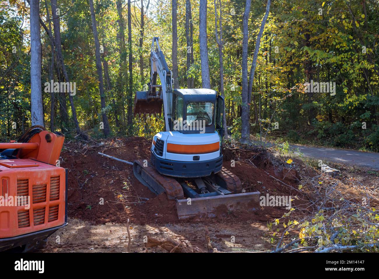 Using tractor to uproot trees in preparation for construction prepare