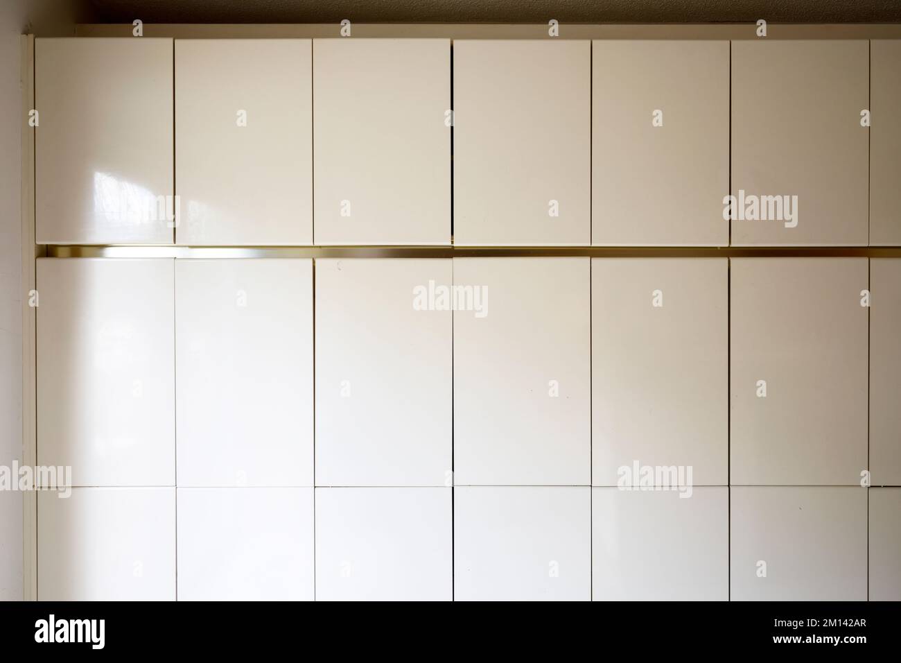 A wall of cream coloured cupboards. This house is now demolished. Stock Photo
