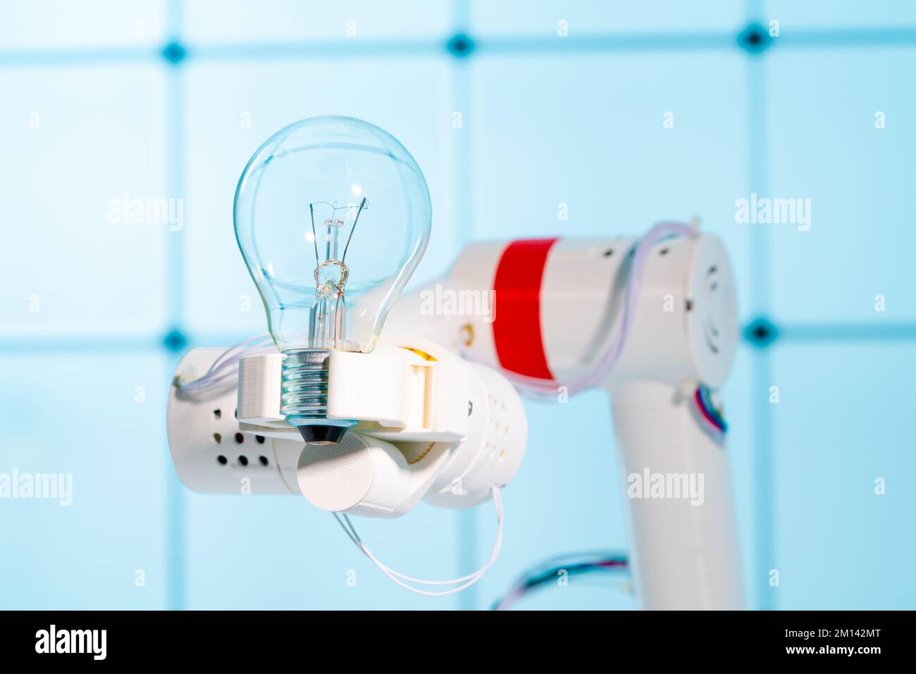Robotic arm holding  bulb Stock Photo