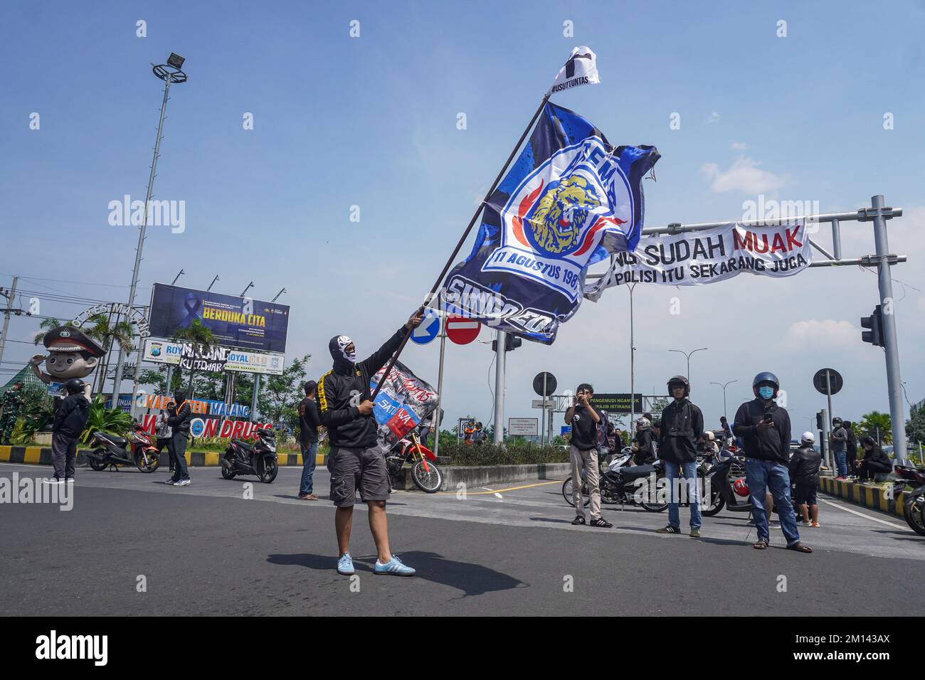 A demonstrator carries a flag with the Crazy Lion logo of the soccer team Arema FC, during the protest. Aremania, the supporters of Arema FC, held a rally and blocked streets in some spots in Malang to protest the legal process of the soccer stampede tragedy, which killed 135 people due to the police tear gas at Kanjuruhan Stadium on October 1, 2022. (Photo by Dicky Bisinglasi / SOPA Images/Sipa USA) Stock Photo