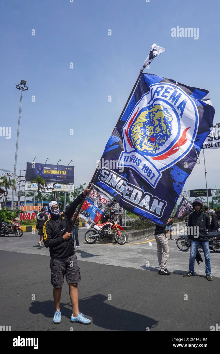 Malang, East Java, Indonesia. 8th Dec, 2022. A demonstrator carries a flag with the Crazy Lion logo of the soccer team Arema FC, during the protest. Aremania, the supporters of Arema FC, held a rally and blocked streets in some spots in Malang to protest the legal process of the soccer stampede tragedy, which killed 135 people due to the police tear gas at Kanjuruhan Stadium on October 1, 2022. (Credit Image: © Dicky Bisinglasi/SOPA Images via ZUMA Press Wire) Stock Photo