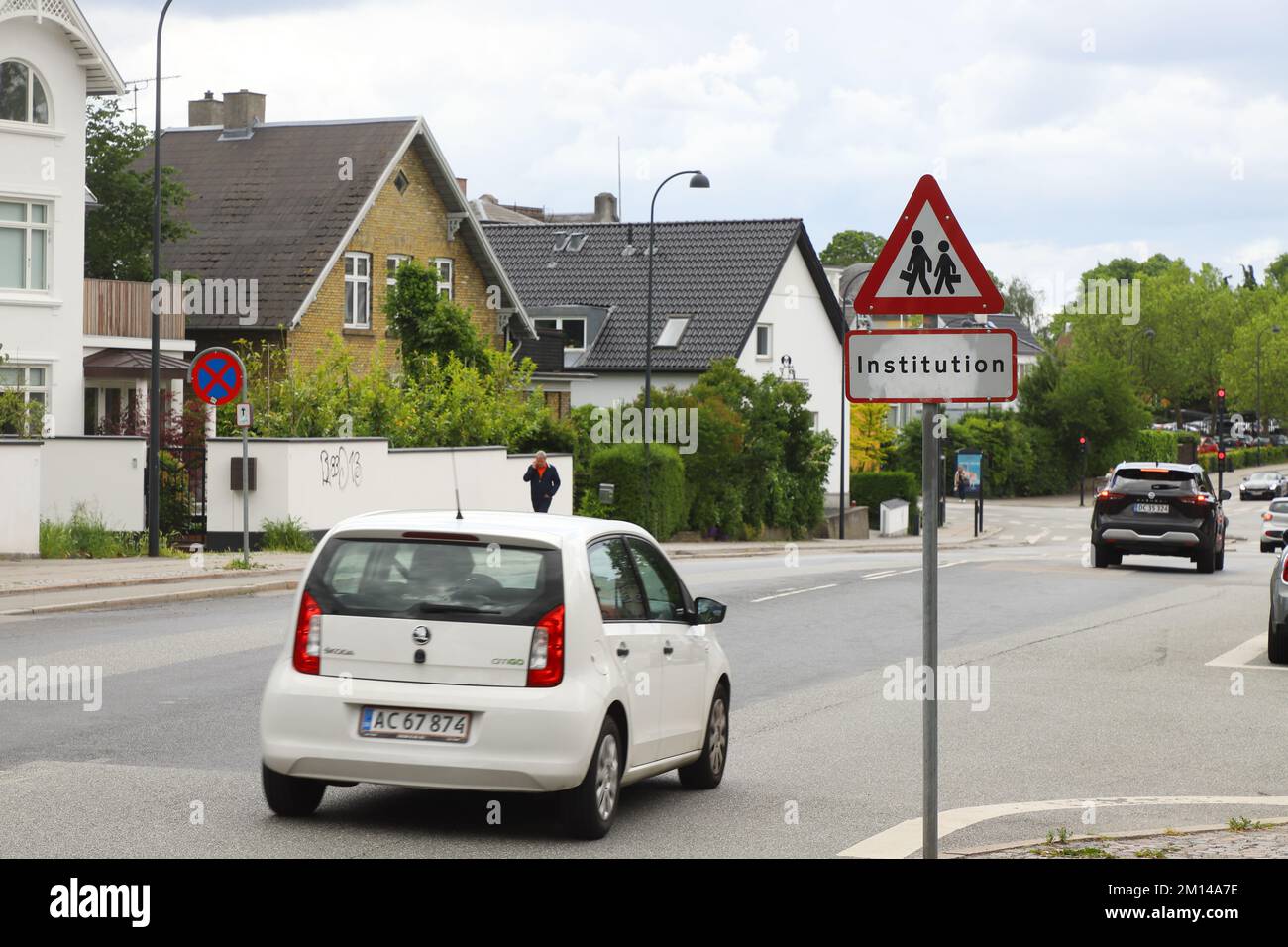 Hellerup, Denmark - June 14, 2022: Road sign warning for children near a school on a suburban street with detached houses. Stock Photo