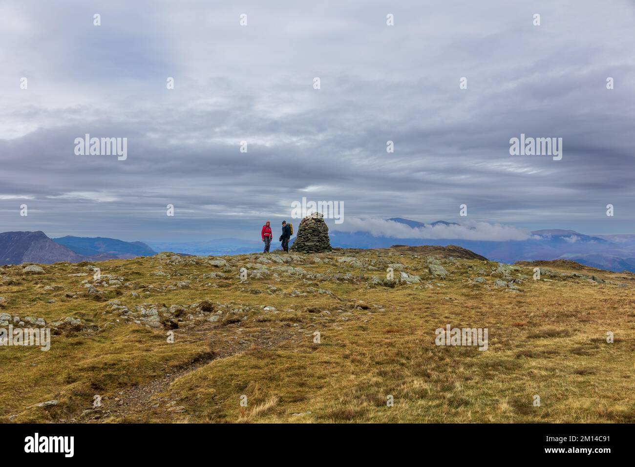Two hikers at the summit cairn of High Spy, a Wainwright, in the English Lake District Stock Photo