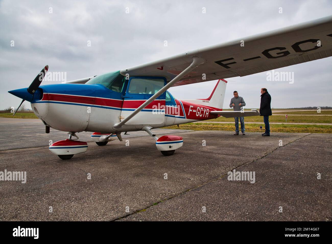 CAEN, FRANCE - JUNE Circa 2016. Private Cesna aircraft on the tarmac of a small regional airport with pilot and customer inspecting plane before fligh Stock Photo