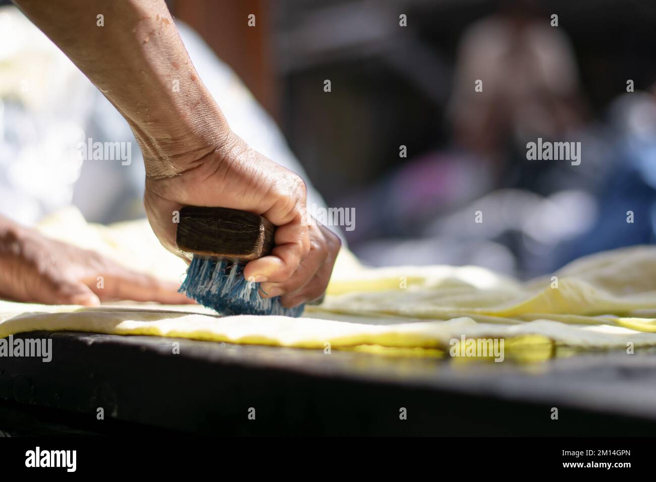Hands of a man with a brush washing the clothes in Dhobi Ghat, Mumbai, India. Indian Labour, worker or labor, poor and hard working. Skill India. Swan Stock Photo