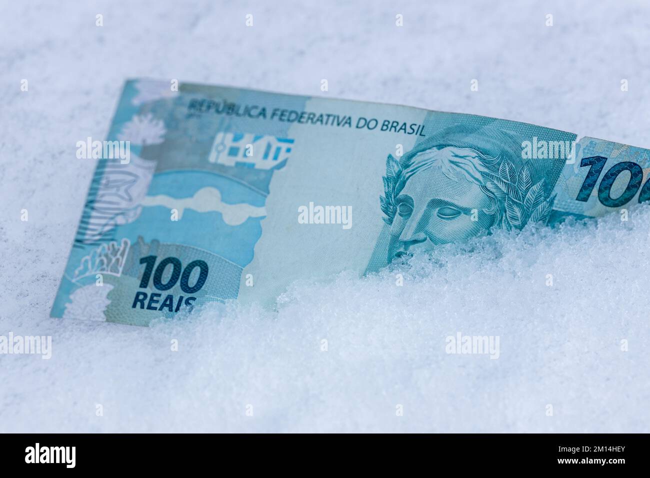 Brazil money, 100 reais banknote lying in the snow, financial concept, spending freeze Stock Photo