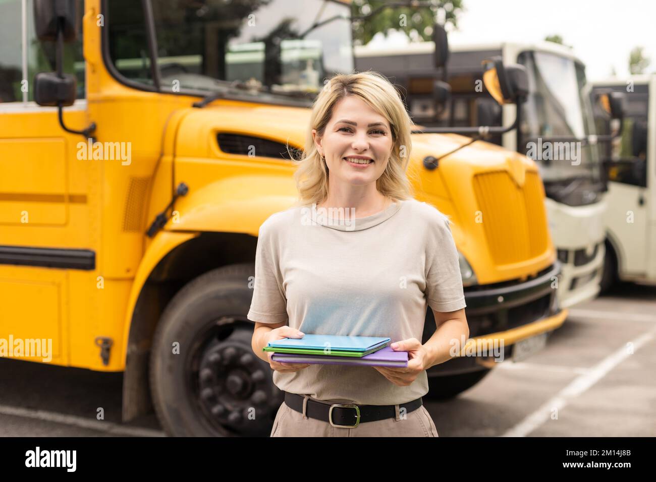 Teacher of elementary school near the school bus Stock Photo - Alamy