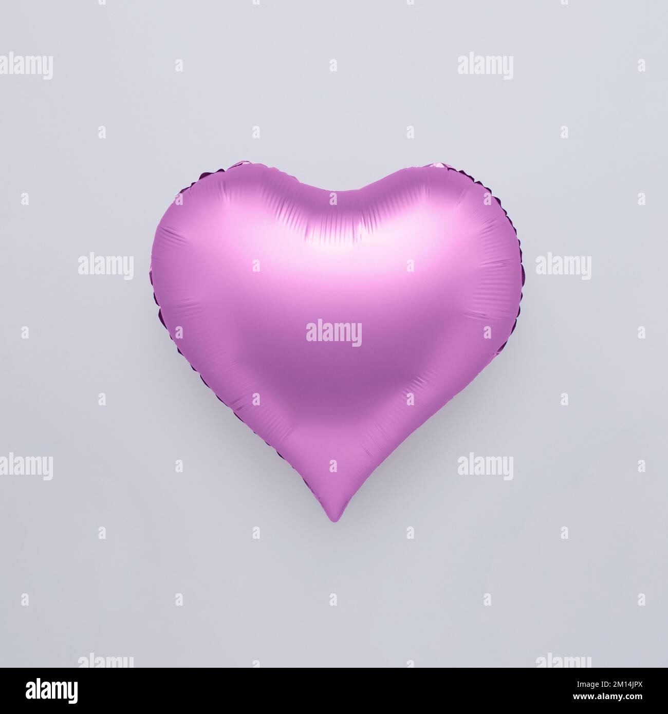 A purple heart shaped balloon isolated on a white background - the ...