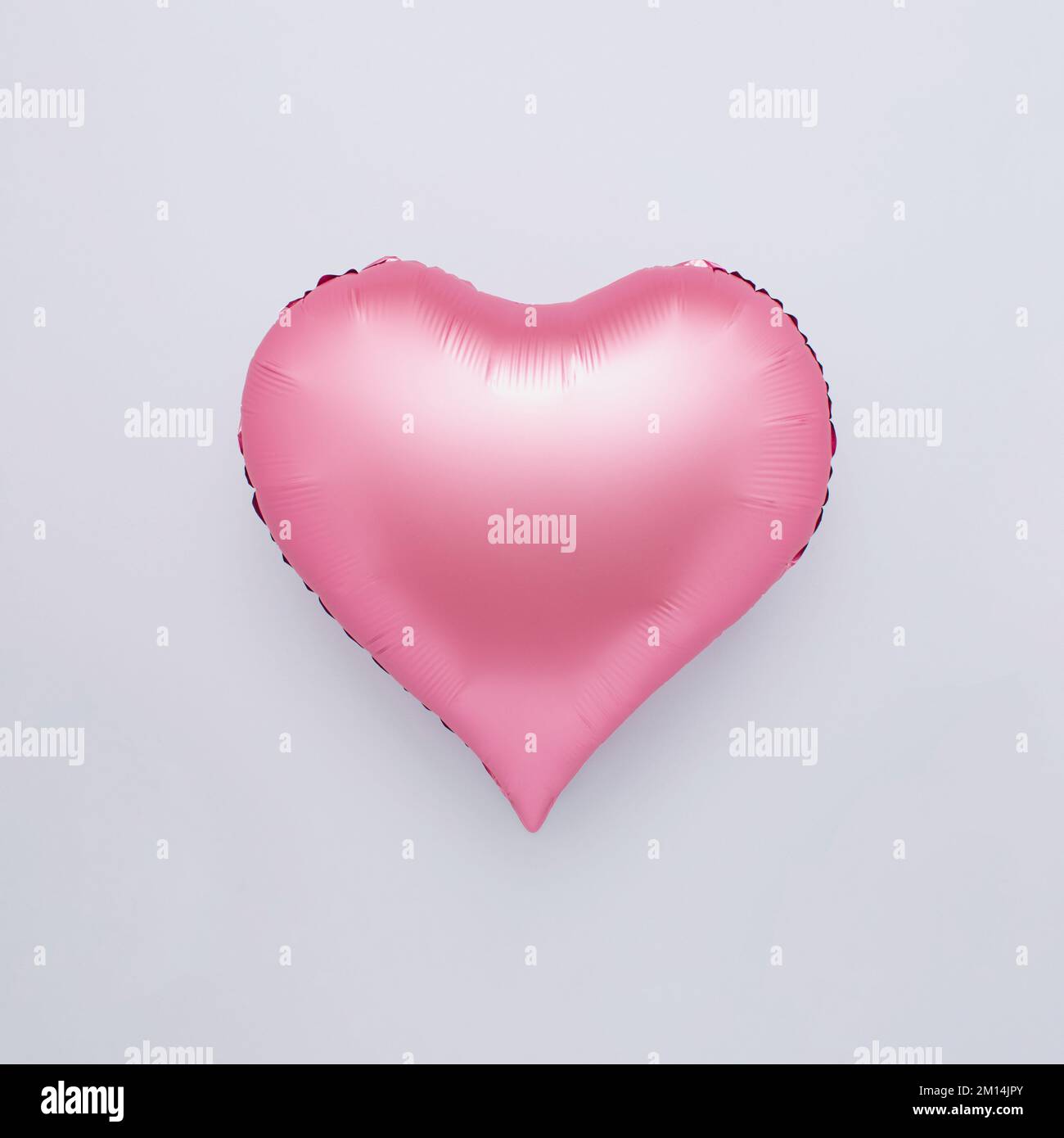A pink heart shaped balloon isolated on a white background - the ...