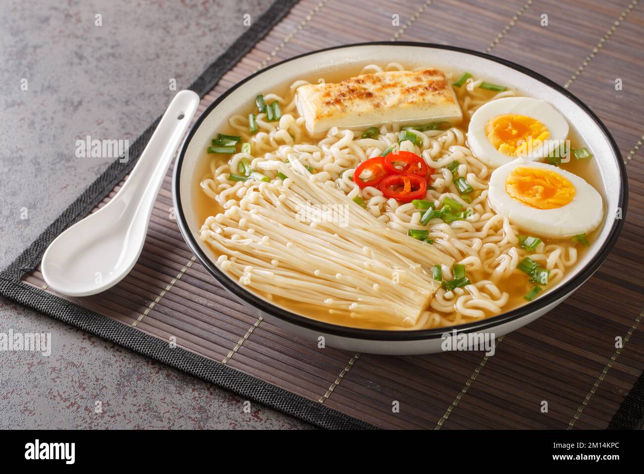 Spicy miso ramen soup with tofu, enoki mushrooms, noodles, green onion