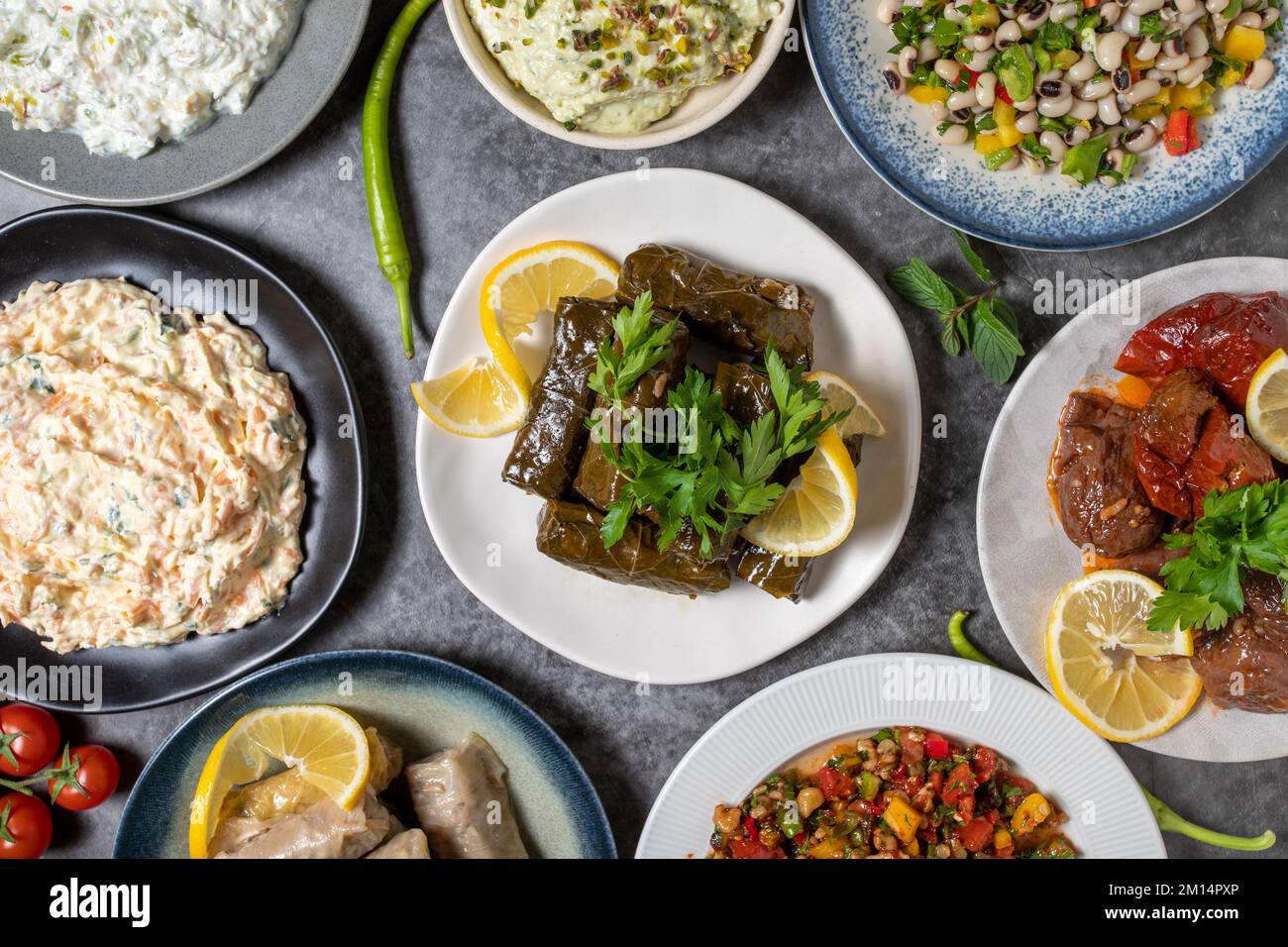 Top view traditional Turkish and Greek dinner appetizer table. Mediterranean appetizer concept. Raw meatballs, roasted eggplant salad, stuffed olives, Stock Photo