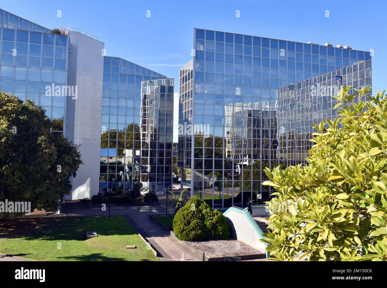 Office complex facing  the Canal du Midi, in Toulouse, France, largely clad in mirrored-glass, in pleasantly landscaped grounds Stock Photo