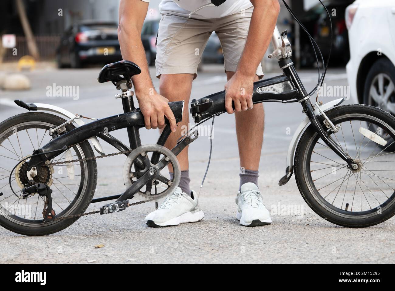 Man holding bicycle with a frame broken in half on the street Stock