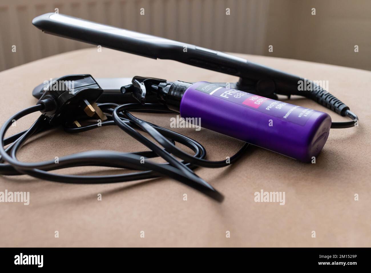 Hair straightening irons with a bottle of heat protect spray Stock