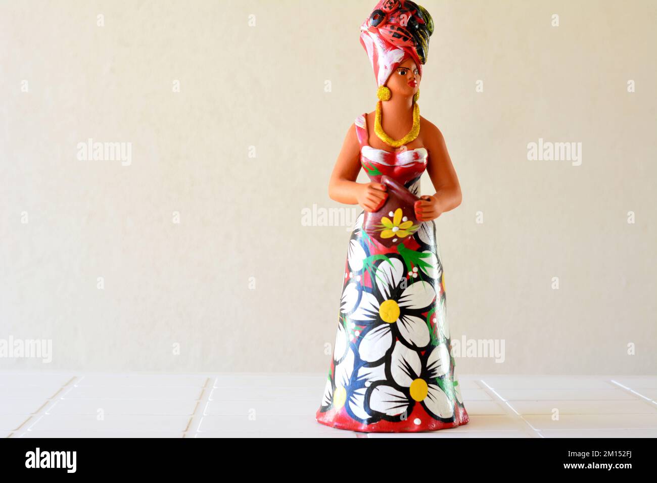 Marilia, São Paulo, Brazil - 07 April 2022: Craftsmanship. Clay woman, handmade in Brazil, South America, Latin America, side view with white backgrou Stock Photo