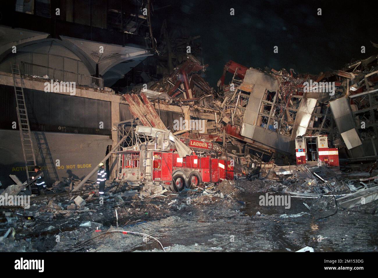 A New York City Fire Department chief examins the remains of FDNY Ladder 3 and Rescue 1 as they lie destroyed under the north walkway of West Drive on Stock Photo