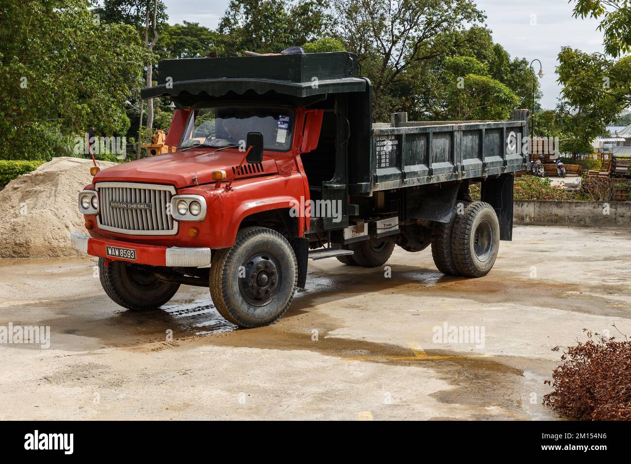 Air Itam, Penang, Malaysia - November 27, 2017: Old Nissan Diesel Truck. car with a red cab is standing on a construction site. Stock Photo