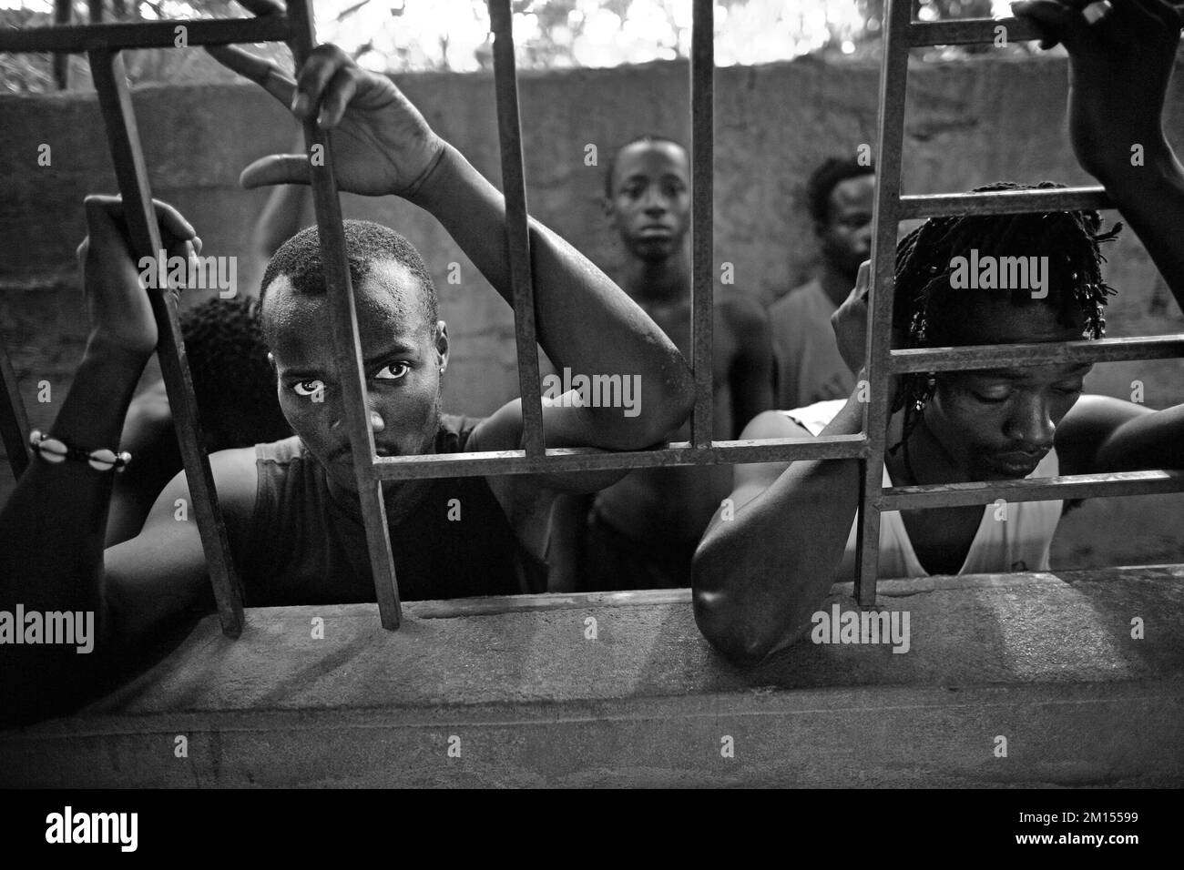 African man looking through window with bars in Bamako , Mali , West Africa . Stock Photo