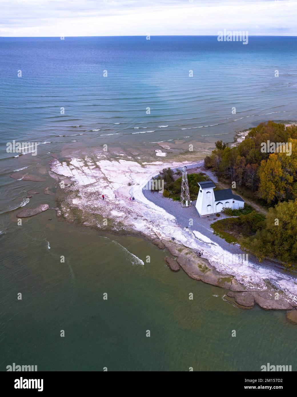 An aerial view of a house on the shore near the sea on a sunny day ...