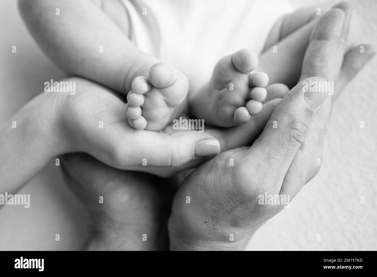 Baby feet in the hands of mother, father, older brother or sister, family. Stock Photo