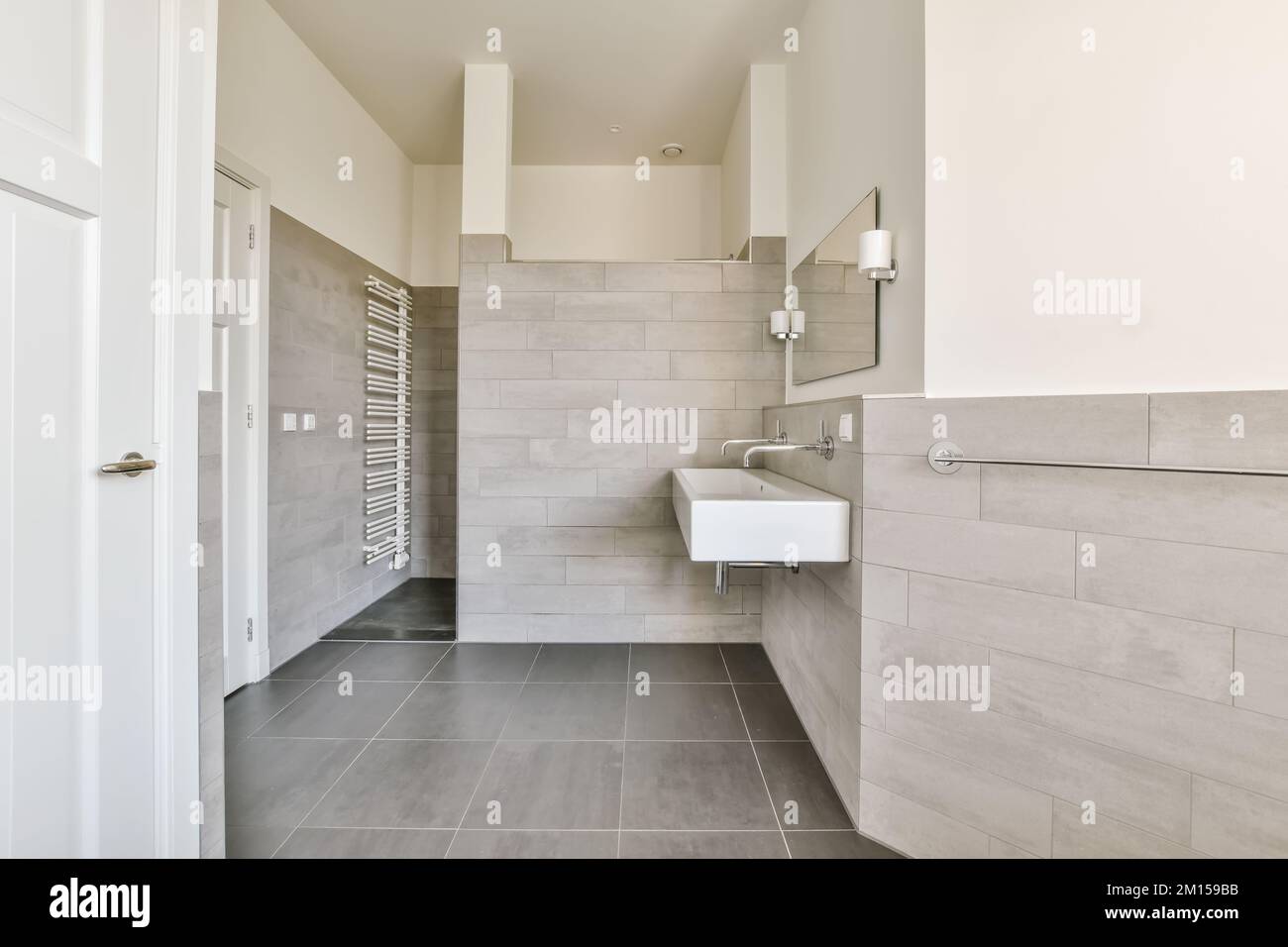 a modern bathroom with grey tile flooring and wall mounted toilet roll