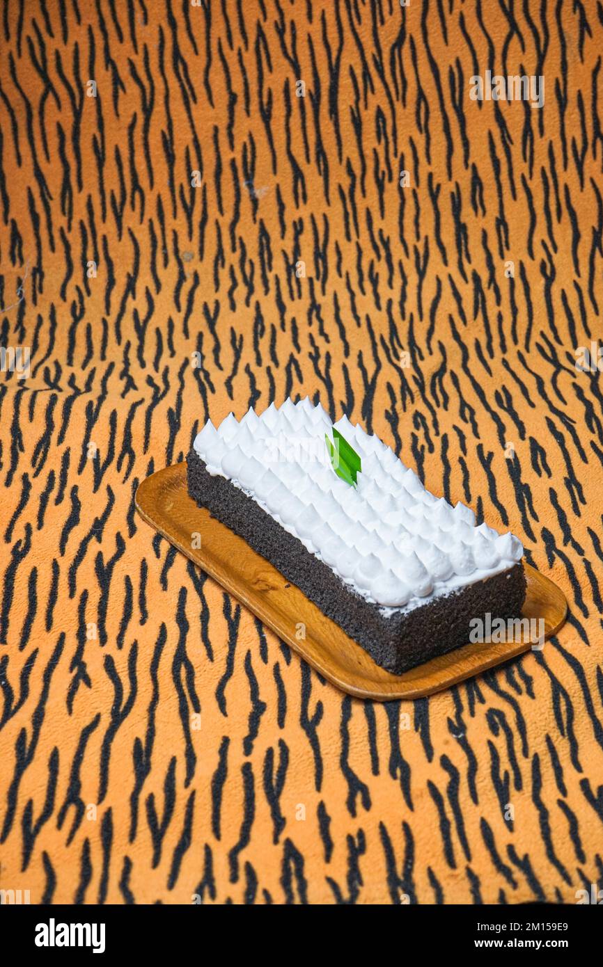 A closeup of Jane Parker Spanish bar cake on the brown striped background Stock Photo