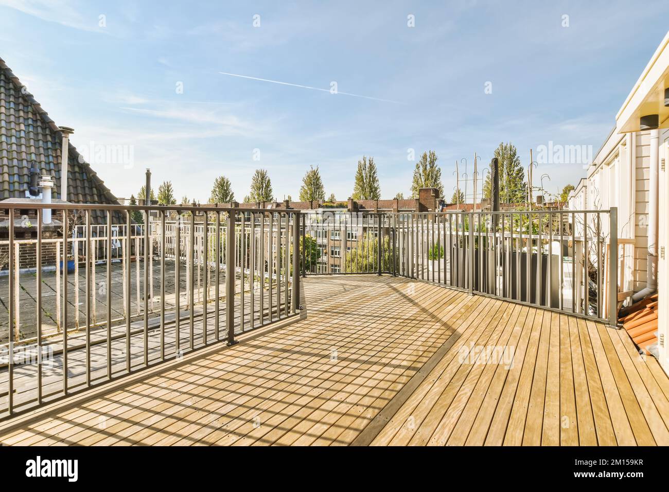 Curated visual reference: Gallery Detail: A Wooden Deck With Metal Railings And Buildings In The